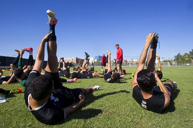 UNLV soccer players stretch at the conclusion of practice as head coach Rich Ryerson looks on Thursday, Sept. 18, 2014.