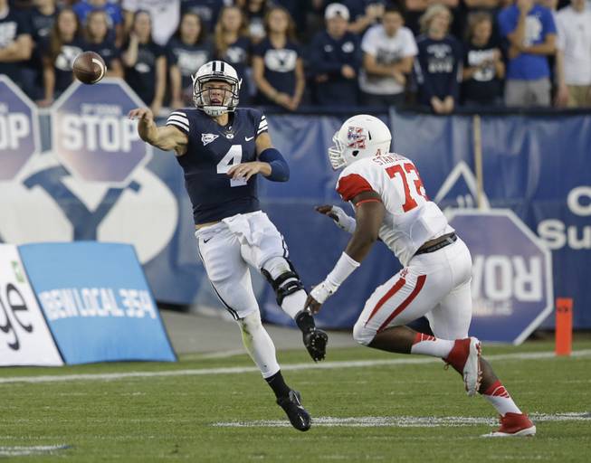 Brigham Young quarterback Taysom Hill (4) passes the ball as Houston defensive end Gavin Stansbury (72) defends in the first quarter during an NCAA college football game Thursday, Sept. 11, 2014, in Provo, Utah.(AP Photo/Rick Bowmer)