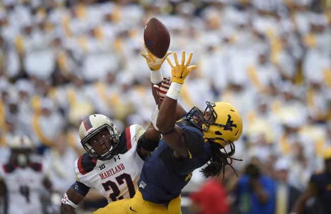 Maryland defensive back Alvin Hill, left, breaks up a pass intended for West Virginia wide receiver Kevin White, right, during the first half of an NCAA football game, Saturday, Sept. 13, 2014, in College Park, Md. (AP Photo/Nick Wass)