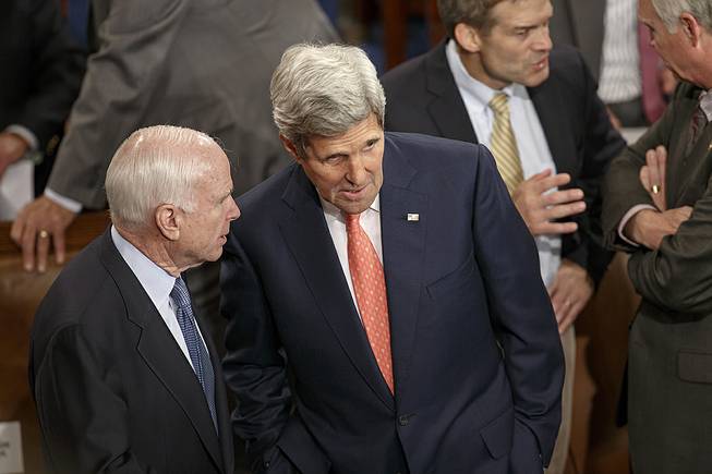 Sen. John McCain, R-Ariz., left, speaks with Secretary of State John Kerry, as lawmakers gather in the chamber of the House of Representatives for a joint meeting of Congress, at the Capitol in Washington, Thursday, Sept. 18, 2014, before a speech by visiting Ukranian President Petro Poroshenko. 