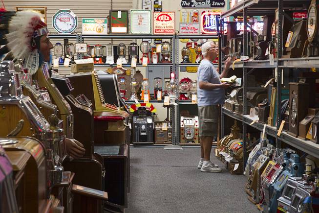 A man looks over a shelf of antique slot machine and other collectables during an auction at Victorian Casino Antiques, 4520 Arville St., Sunday Sept. 21, 2014. The William F. Harrah Antique Gambling Machine collection was the centerpiece of a three-day live auction event. The collection included more than 90 upright slot machines, trade stimulators, three-reelers and floor consoles hailing from the late 1800s to the mid-1900s.