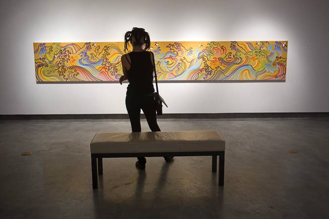 Felicia Mora, a UNLV graduate, looks over a work by Sush Machida, part of the Ghost Dogs: Japanese-American Legends exhibit in the Donna Beam Fine Art Gallery at UNLV Monday, Sept. 22, 2014. The exhibit closes Saturday, Sept. 27.