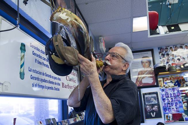 Geraldo Carranza blows into a horn at Geraldo's Classic Barber Shop, 3869 Spring Mountain Rd., Sunday Sept. 21, 2014. The shop is filled with boxing and barber memorabilia as well as souvenirs from his travels.
