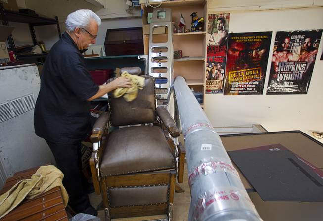 Geraldo Carranza dusts off an antique barber chair, currently in storage, at Geraldo's Classic Barber Shop, 3869 Spring Mountain Rd., Sunday Sept. 21, 2014. The Koken barber chair was used in the Windsor Hotel in Denver in the late 1800's. The hotel was demolished in 1959.