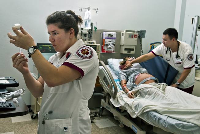 Nursing students Jessica Patterson and John Ho tend to Sim Mom who is feeling nauseous during a patient simulation lab with mannequins in the nursing program at Roseman University on Thursday, September 18, 2014.  L.E. Baskow.