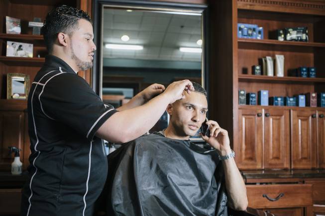 Juan Ramirez cuts Kamran Zana's hair at Fino for Men in Las Vegas, Nev. on September 20, 2014.