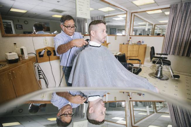 Ernesto Ortiz cuts Chris Kellam's hair at the El Cortez Barbershop in Las Vegas, Nev. on September 20, 2014.