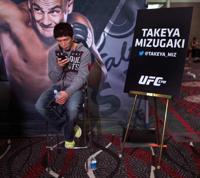 Bantamweight fighter Takeya Mizugaki kills time while awaiting reporters to interview him during UFC 178 media day at the MGM Grand Arena on Thursday, September 25, 2014. .