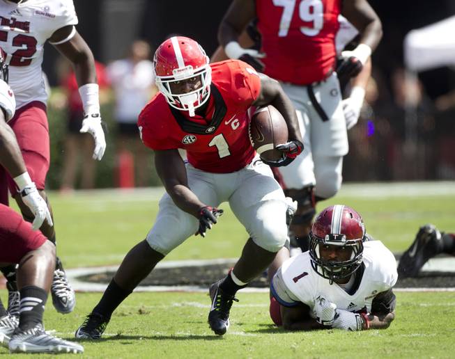 DUPLICATE***Georgia running back Sony Michel (1) gets past Troy defensive back Montres Kitchens (1) in the first half of an NCAA college football game Saturday, Sept. 20, 2014, in Athens, Ga. (AP Photo/John Bazemore)