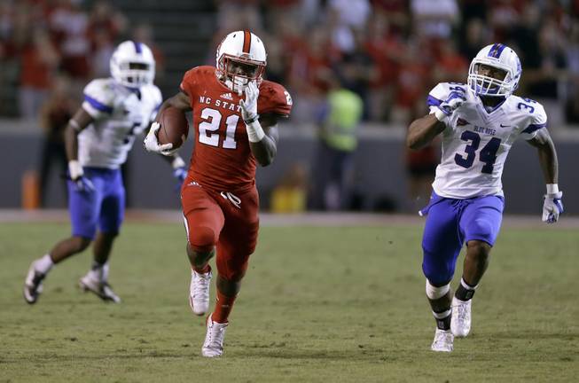 North Carolina State's Matt Dayes (21) runs for a touchdown as Presbyterian's Breyon Williams (34) chases during the second half of an NCAA college football game in Raleigh, N.C., Saturday, Sept. 20, 2014. North Carolina State won 42-0. (AP Photo/Gerry Broome)