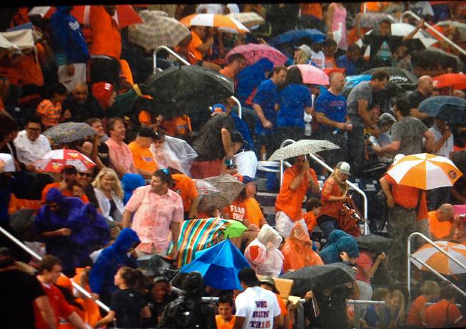 Fans at Bishop Gorman's Fertitta Field take cover when rain begins to fall, Friday, Sept. 26, 2014.
