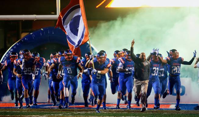 Bishop Gorman players take the field after a rain delay for their game against St. John Bosco on Friday, Sept. 26, 2014.