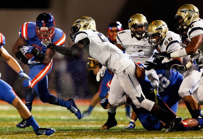 Bishop Gorman's Russell Booze #24 fights off a St. John Bosco tackle attempt on Friday, September 26, 2014.