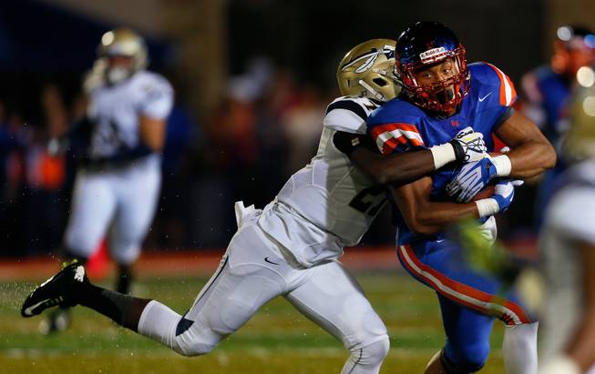 Bishop Gorman's Alize Jones #8 secures the ball after a catch and run for yardage during the game versus St. John Bosco on Friday, September 26, 2014. .