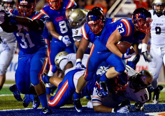 Bishop Gorman's Jonathan Shumaker #33 blast into the end zone for a touchdown over the St. John Bosco's defense on Friday, September 26, 2014.