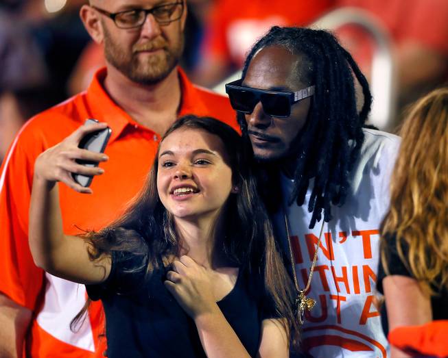 Snoop Dogg takes time to have a picture taken with a Bishop Gorman fan in the stands during the game versus St. John Bosco on Friday, September 26, 2014.