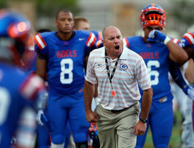 Bishop Gorman head coach Tony Sanchez yells instructions to a player as his team warms up before a game Friday, Sept. 26, 2014, against St. John Bosco.