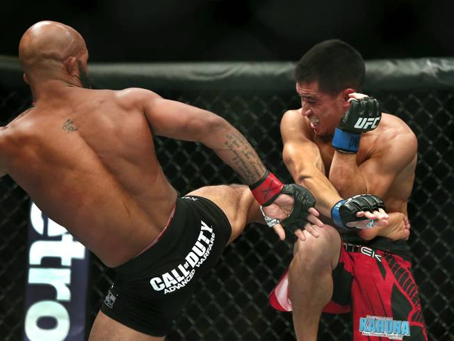 Flyweight title fighter Demetrious Johnson connects with a kick to the ribs on Chris Cariaso during UFC 178 at the MGM Grand Garden Arena on Saturday, Sept. 27, 2014. 