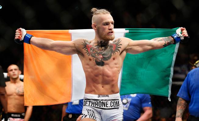 Featherweight fighter Conor McGregor wraps an Irish flag around himself after beating Dustin Poirier during UFC 178 at the MGM Grand Garden Arena on Saturday, September 27, 2014.