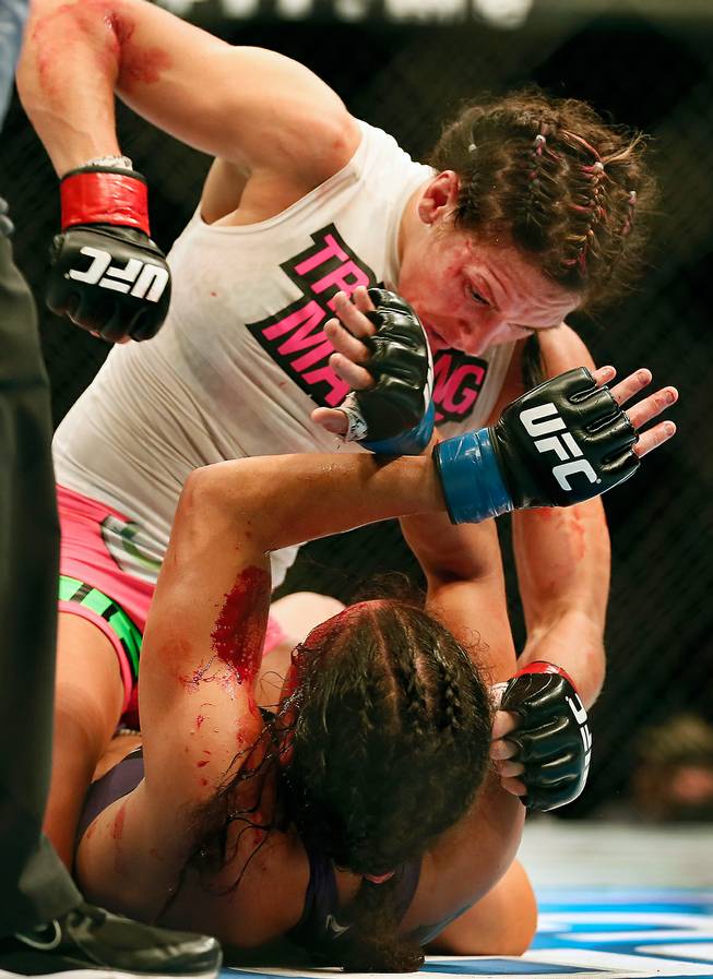 Women's Bantamweight fighter Cat Zingano aims another fist at the face of opponent Amanda Nunes who is bloodied and done during UFC 178 at the MGM Grand Garden Arena on Saturday, September 27, 2014.