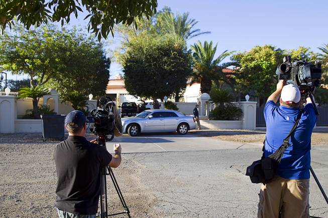 News photographers photograph an FBI raid at a home on Oquendo Road near Lamb Boulevard Monday Sept. 29, 2014.