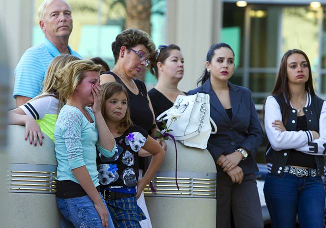 Ron Cornell's granddaughter Ember Hutchins, left, 11, gets emotional as Cornell speaks on the death of his son during a ceremony to honor the lives of homicide victims, including those killed by domestic violence, at Metro Police Headquarters Tuesday, Sept. 30, 2014. Cornell's son Joey was killed in 1998.