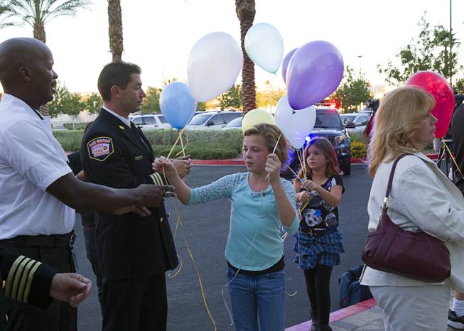Ember Hutchins, left, 11, and Jacey Cornell, 8, during a ceremony to honor the lives of homicide victims, including those killed by domestic violence, at Metro Police Headquarters Tuesday, Sept. 30, 2014.