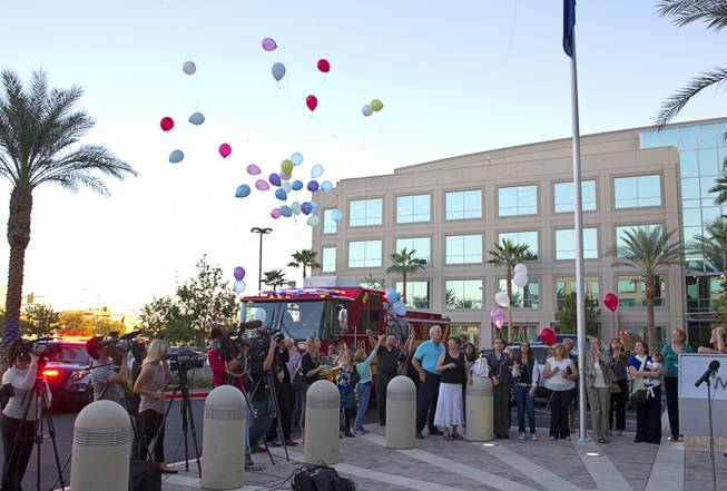 Balloons are released during a ceremony to honor the lives of homicide victims, including those killed by domestic violence, at Metro Police Headquarters Tuesday, Sept. 30, 2014.