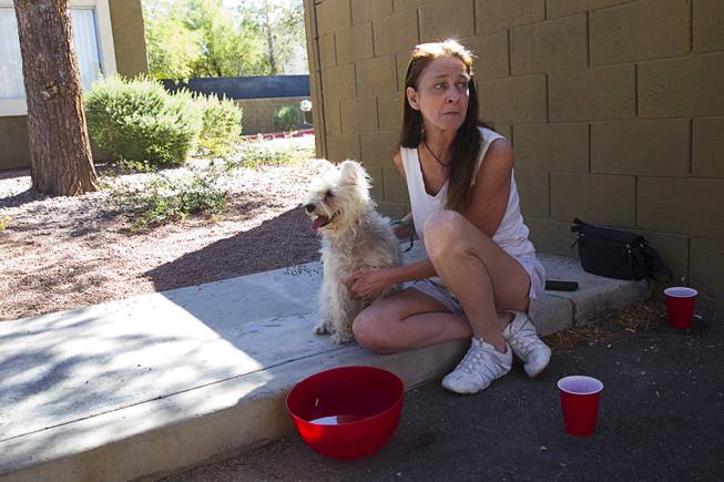 Teri English waits with her dog Twitch after being displaced by an apartment fire in Henderson Tuesday, Sept. 30, 2014. One man died in an upstairs unit after a fire started between the first and second floor, said Henderson Public Information Officer Kathleen Richards.