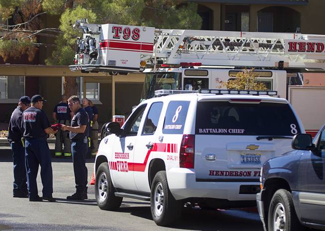 Henderson firefighters confer after a fatal apartment fire in Henderson Tuesday, Sept. 30, 2014.