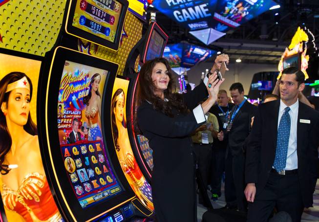 Lynda Carter takes a selfie in front of the Wonder Woman slot machines during the Global Gaming Expo at the Sands Expo, Tuesday, Sept. 30, 2014.