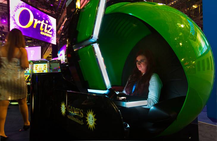 Kristen Marschner of Dresden, Germany, tries the new Ozone slot machine by Merkur Gaming during the Global Gaming Expo (G2E) at the Sands Expo onTuesday, September 30, 2014.