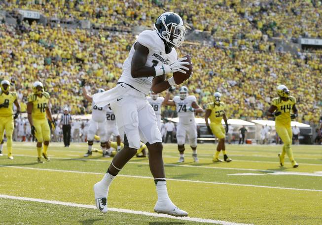 Michigan State's Tony Lippett comes down with a touchdown reception against Oregon during the second quarter of their college football game in Eugene, Oregon, Saturday Sept. 6, 2014. (AP Photo/Chris Pietsch)