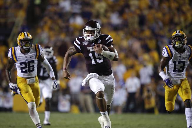 Mississippi State quarterback Dak Prescott (15) rushes for a touchdown in the second half of an NCAA college football game against LSU in Baton Rouge, La., Saturday, Sept. 20, 2014. (AP Photo/Gerald Herbert)
