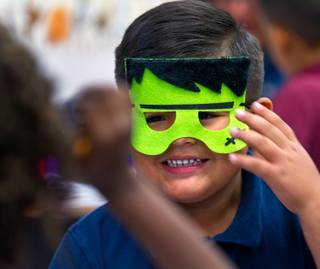 Brian Baltazar puts on a Frankenstein mask as part of a literacy station during kindergarten class in Raeleen Martinez's room at Martinez Elementary School on Tuesday, October 7, 2014.