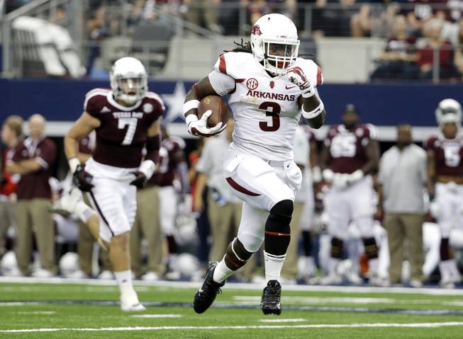 Arkansas running back Alex Collins (3) sprints past Texas A&M linebacker Jordan Mastrogiovanni (7) for a long run on his way to the end zone for a touchdown in the first half of an NCAA college football game, Saturday, Sept. 27, 2014, in Arlington, Texas. (AP Photo/Tony Gutierrez)