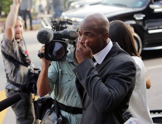 Minnesota Vikings running back Adrian Peterson arrives at court in Conroe, Texas, on Wednesday, Oct. 8, 2014. A judge tentatively set a Dec. 1 trial date for Peterson on a charge of felony child abuse for using a wooden switch to discipline his 4-year-old son this year.