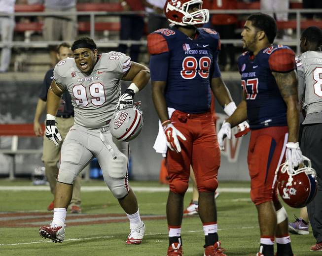 UNLV Rebels defensive lineman Mike Hughes Jr. (99) celebrates after his team defeated the Fresno State Bulldogs in overtime of an NCAA college football game Friday, Oct. 10, 2014, in Las Vegas. The Rebels won 30-27. 