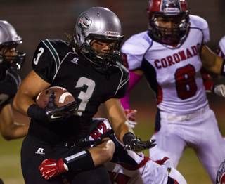 Green Valley's .Brenan Adams #3 turns the corner on a run while trying to break a tackle by Coronado's Aaron Cotton #52 on Friday, October 10, 2014.