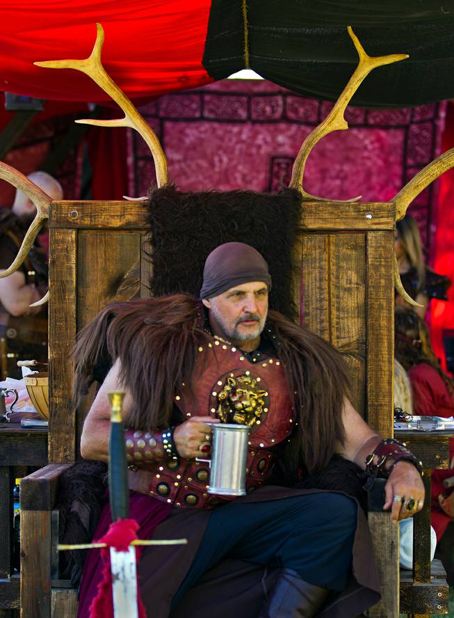 Kyle "Kalim" Nelson enjoys a cup of mead while relaxing on a throne as a member of the Dogs of War Guild during the Renaissance Festival at Sunset Park on Saturday, October 11, 2014.