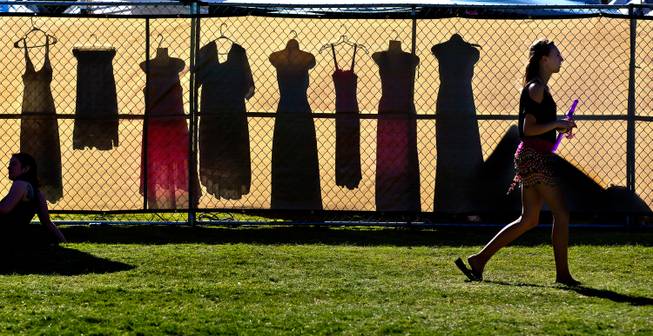 Dresses for sale cast shadows on the other side of the fence in the Vendor Village within the Renaissance Festival at Sunset Park on Saturday, October 11, 2014.