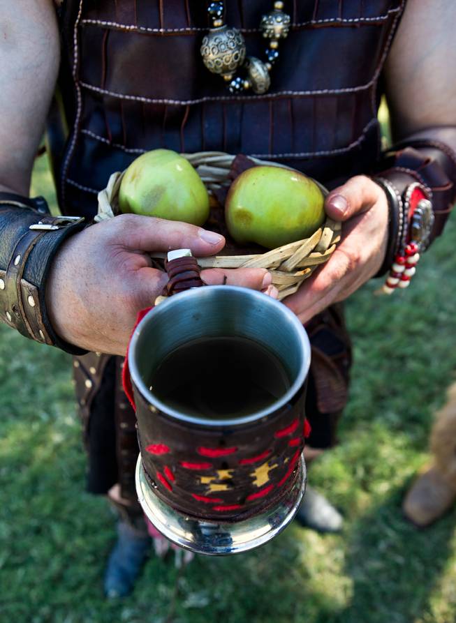 A member of the Dogs of War Guild has a snack and some mead as part of the Renaissance Festival at Sunset Park on Saturday, October 11, 2014.