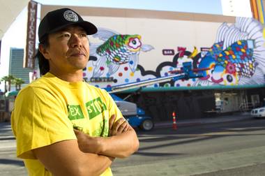Artist Sush Machida poses by a mural he is creating with fellow artist Tim Bavington on the side of the Emergency Arts building at Fremont and Sixth streets in downtown Las Vegas Sunday, Oct. 12, 2014.