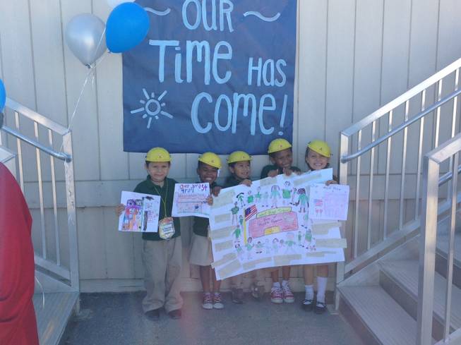 A group of West Preparatory Academy kindergarten students hold drawings of what they envision they're new, permanent elementary school building will look like on Monday, Oct. 13, 2014. The Clark County School District will begin construction on the $18 million elementary school building in nine months. 