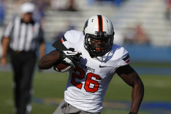 Oklahoma State running back Desmond Roland (26) during the first half of an NCAA college football game against Kansas in Lawrence, Kan., Saturday, Oct. 11, 2014. (AP Photo/Orlin Wagner)