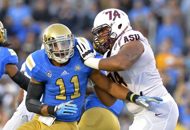 UCLA linebacker Anthony Barr, left, tries to get by Arizona State offensive linesman Jamil Douglas during the first half of an NCAA college football game, Saturday, Nov. 23, 2013, in Pasadena. (AP Photo/Mark J. Terrill)
