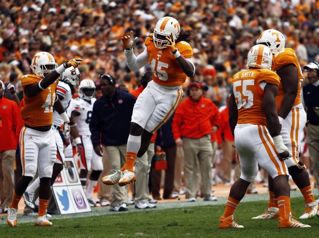 Tennessee linebacker A.J. Johnson (45) reacts to a tackle with teammates linebacker Dontavis Sapp (41), and defensive lineman Jacques Smith (55) in the first quarter of an NCAA college football game on Saturday, Nov. 9, 2013 in Knoxville, Tenn. (AP Photo/Wade Payne)