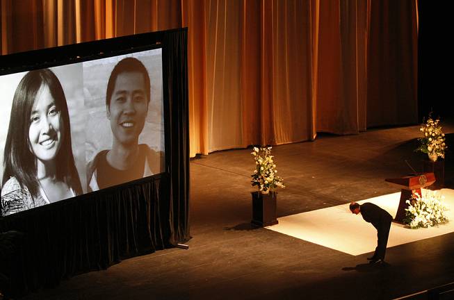 In this April 18, 2012 file photo, University of Southern California president C. L. Max Nikias bows before images of victims Ying Wu, left, and Ming Qu before eulogizing the slain engineering students during a memorial service at the Shrine Auditorium in Los Angeles. Jurors in the case of a man charged with the murders of the Chinese students at USC were played a videotape Thursday, Oct. 16, 2014, where he bragged about the shootings. 