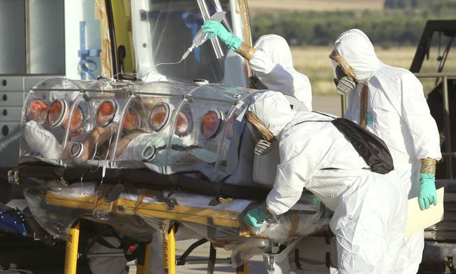 In this Aug. 7, 2014, file photo provided by the Spanish Defense Ministry, aid workers and doctors transfer Miguel Pajares, a Spanish priest who was infected with the Ebola virus while working in Liberia, from a plane to an ambulance as he leaves the Torrejon de Ardoz military airbase, near Madrid, Spain.