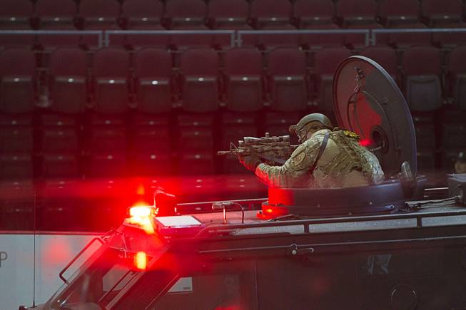 A Metro SWAT officer aims his rifle at a "bad guy" in a half-time show during the 24th Annual Las Vegas Police K9 Trials at the Orleans Arena Sunday, Oct. 19, 2014.